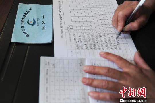 图为工作人员在为村民“生态美超市”进行登记积分。 张娅子 摄