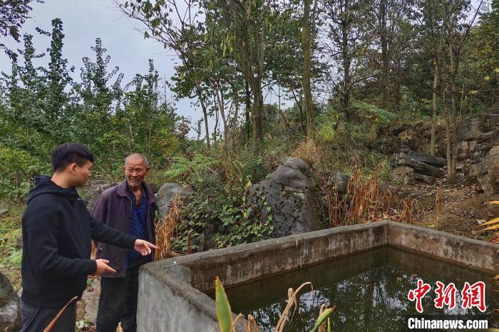 杨帆(左)在村民家查看用水情况(资料图) 五峰县委宣传部 供图